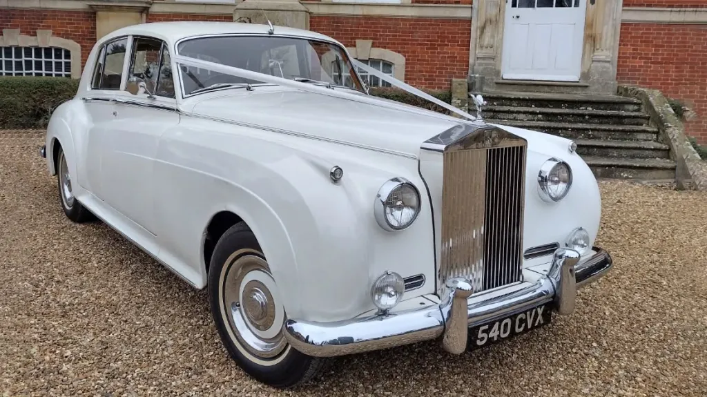 Classic Rolls-Royce Silver Cloud in White with white ribbons across its long bonnet