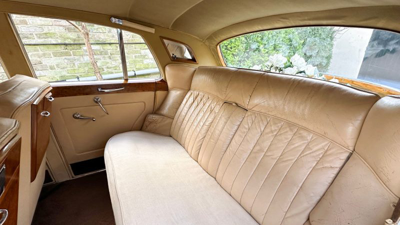 Interior photo of rear cream leather seats of cream Leather interior and wooden picnic table fitted in the back of the front passenger's seats