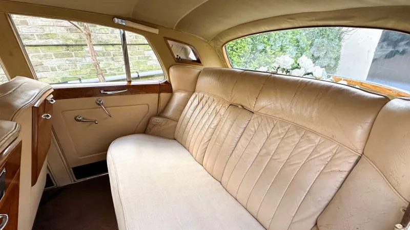 Interior photo of rear cream leather seats of cream Leather interior and wooden picnic table fitted in the back of the front passenger's seats
