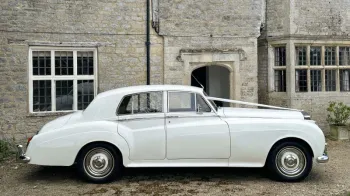 right side view of White Classic Rolls-Royce white thin white wall tires and wedding ribbons