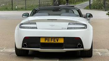 Full rear view of white Astn Martin Vantage with convertible roof open