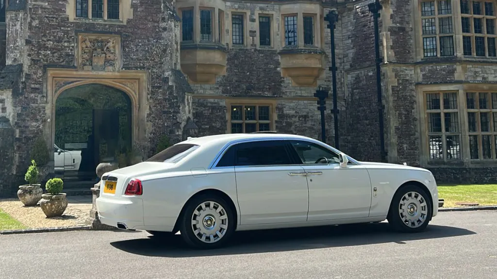 Rear right side of Modern Rolls-Royce Ghost parked in front of Rhinefield House Hotel in the New Forest