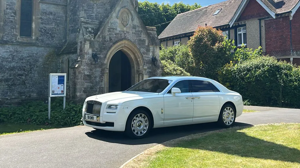 Modern Rolls-Royce Ghost in White parked in front of a church