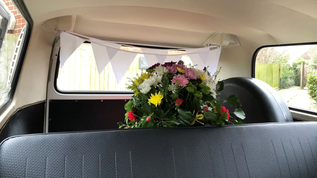 classic vw campervan interior with blue seats and wedding flower decoration