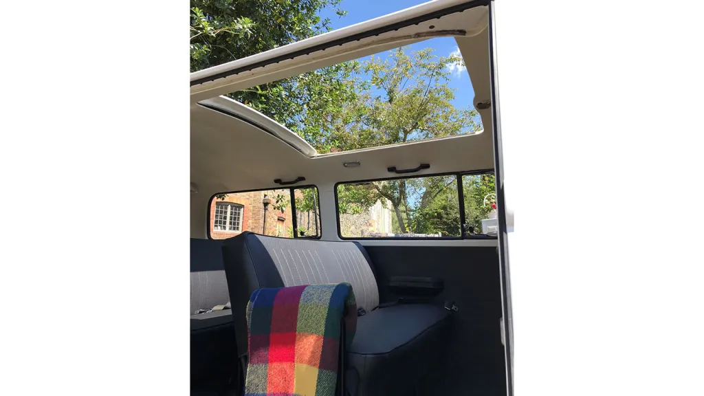 classic campervan interior with blue seats and large open sunroof