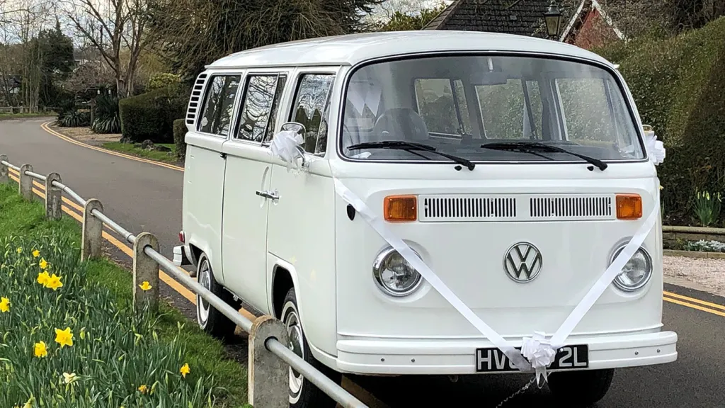 White classic VW Campervan decorated with white ribbons