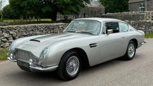 Front left view of a classic Aston Martin DB6 in silver with chrome bumper and chrome spokes wheels