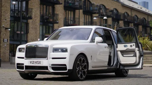 White rolls-Royce cullinan white rear passenger door open showing a cream leather interior