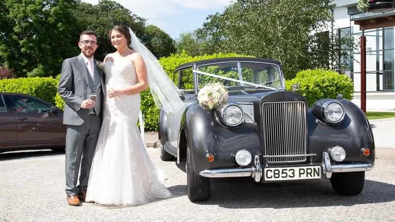 Vintage Royale Windsor in Silver next to Bride and Groom