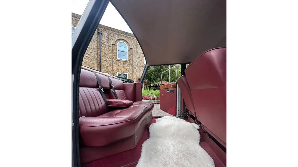 Rear interior of Burgundy leather inside a vintage royale windosr with the semi-convertible roof open