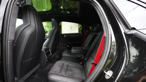 Black Porsche Cayenne GTS rear seating space with view of the panoramic sunroof