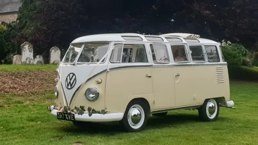 Classic Volkswagen Campervan in White & Cream with Guarlang of flowers on front bumper