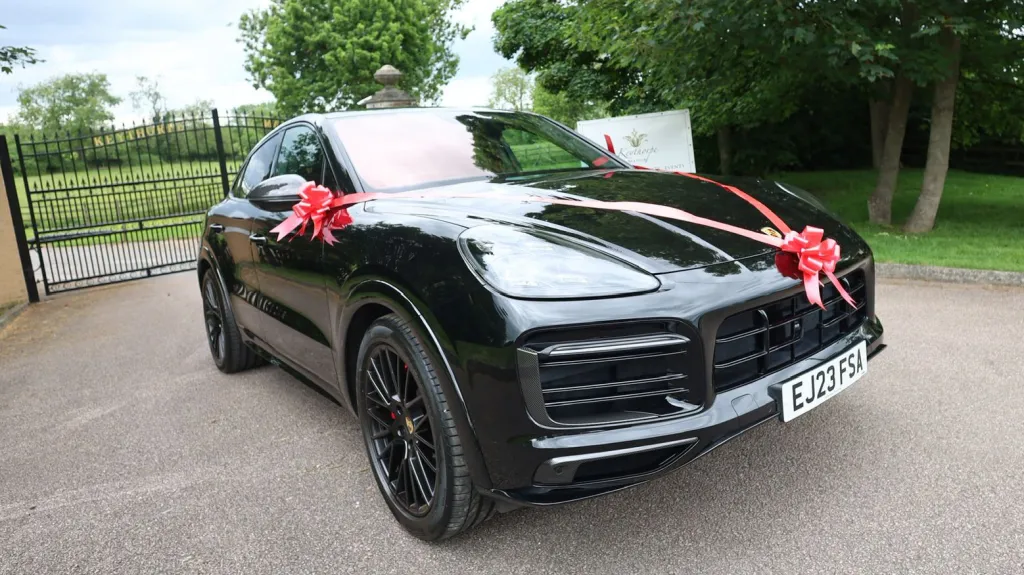 Black Porsche Cayenne GTS front view with wedding ribbons