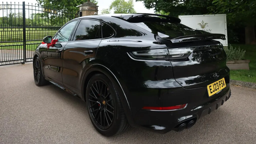 Lefty side rear view Black Porsche Cayenne GTS with black privacy windows