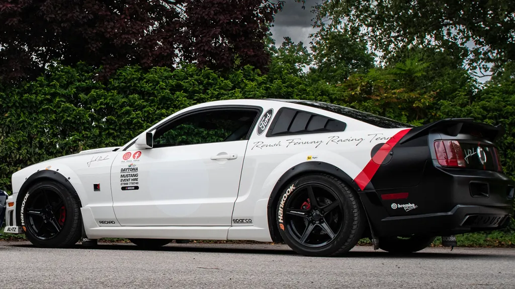 Left side view Ford Mustang in white with black alloy wheels
