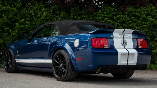 rear view Blue ford mustang with white stripes and black alloy wheels