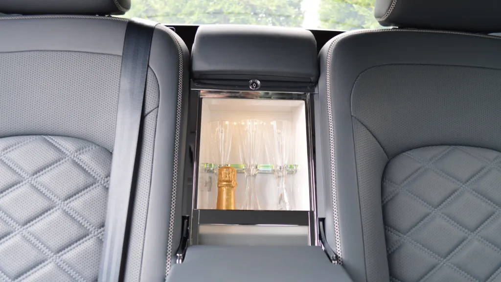 close up view of the mini champagne fridge behing the armreat in the middle of the rear seats inside Bentley
