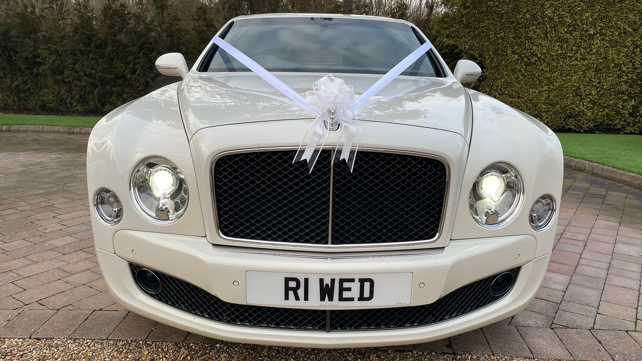 Fill front view of White Bentley Mulsanne decorated with white ribbons and bows