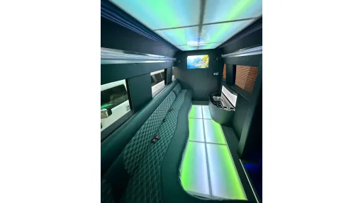 Classic Land Rover decorated with white wedding ribbons and bows