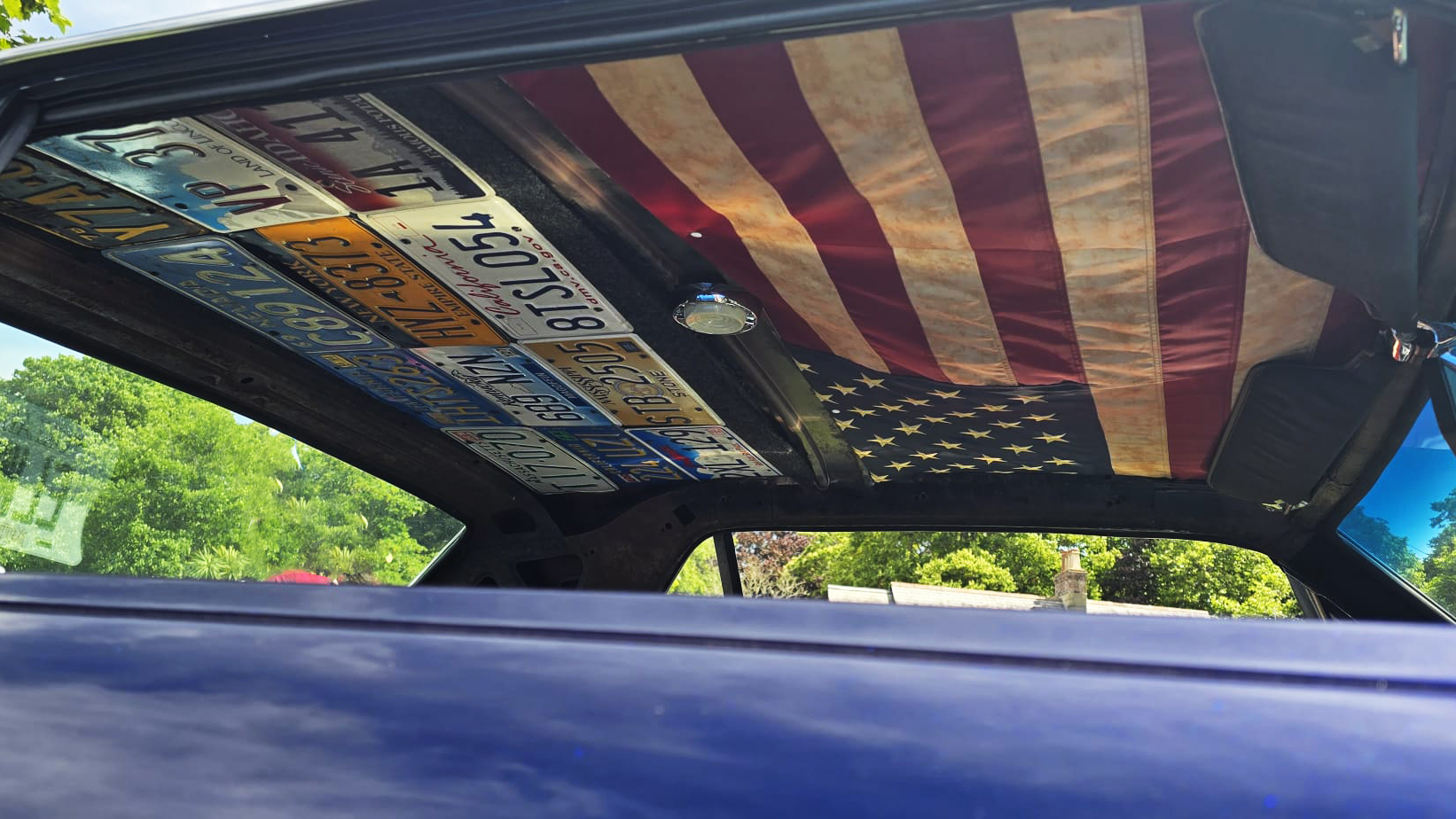 Customised ceiling in Ford Mustang made of an American flag and american car number plates from different states.