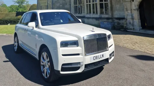 Front Side view of Rolls-Royce Cullinan with rear hinged door open showing a white leather interior