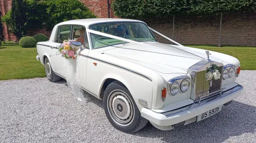 Classic Rolls-Royce Silver Shadow II with ribbonsa and wedding flowers decoration.