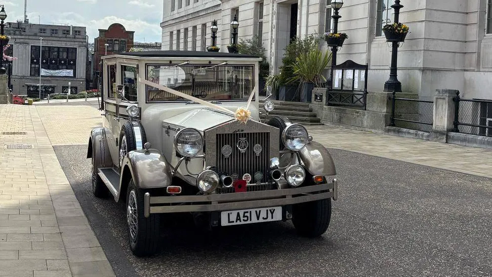 Imperial Viscount Landaulette front view with lare vintage-style headlights and decorated with ribbons and bow
