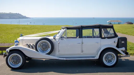 White vintage Beauford left side with black soft top roof closed