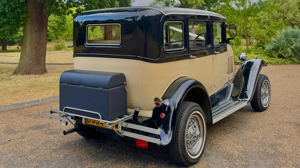 Rear view Ivory Badsworth with black wheel archesd and roof. Rear Picnic trunk , thin white wall tires and chrome bumper