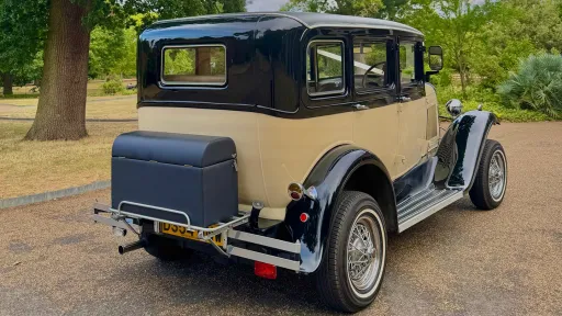 Rear view Ivory Badsworth with black wheel archesd and roof. Rear Picnic trunk , thin white wall tires and chrome bumper