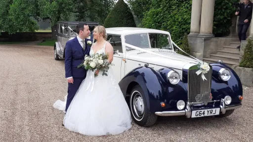 Bride and Groom standing in front of a Blue and Ivory vintage-style Royale Windsor