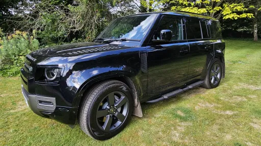 Front left side view of Black Land Rover Defender with black alloy wheels