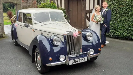 Bride and Groom holding each others next to Vintage-style Royale Windsor