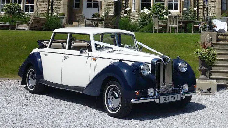 Ivory vintage-style Royale Windsor with blue wheel arches dressed with white weddingribbons