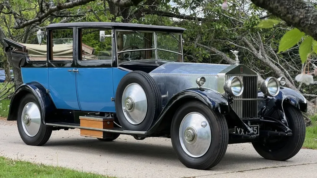 Right side view of vintage rolls-royce phantom 1 in Blue with convertible roof open and sare wheel mounted on the side