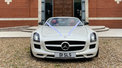 White Mercedes SLS AMG full front view with ribbons accros the front bonnet