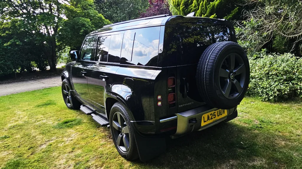 rear view of Black Land Rover Defender with spare wheel mounted at the rear