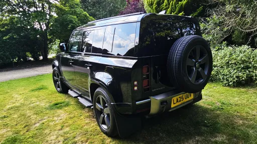 rear view of Black Land Rover Defender with spare wheel mounted at the rear