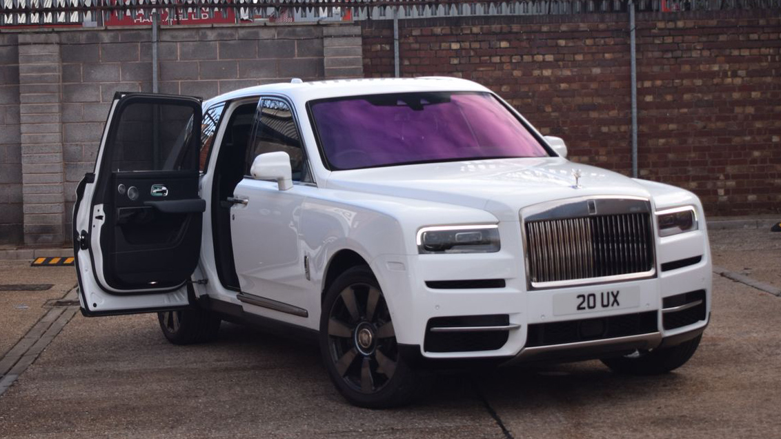 White Rolls-Royce cullinan with rear passenger door open
