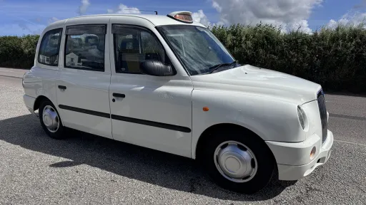 Front left side view of modern white Taxi Cab