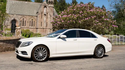Left side view of white mercedes parked in front of a church in Aberdeen and decorated with white ribbons across the bonnet