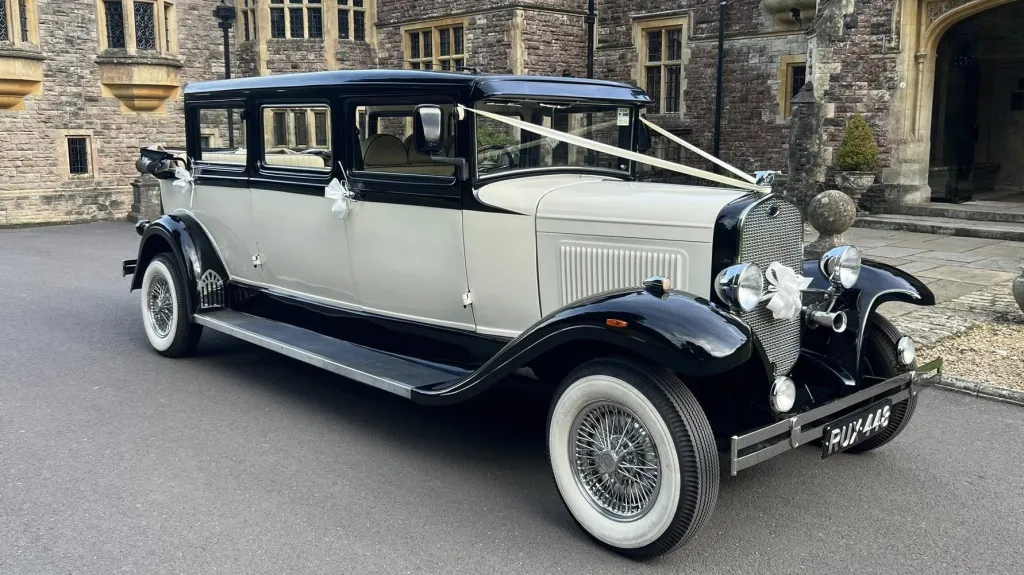 Old English White Bramwith Limousine with black wheel arches and black roof dressed with with ribbons across the bonnet