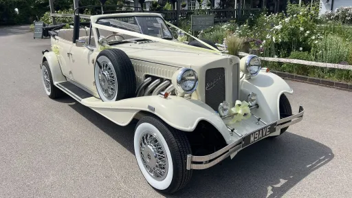 Beauford convertible in Old English White with chrome spokes wheels, large white wall tires and decorated with Ivory ribbon