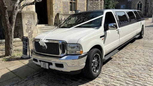 Ford Excursion Stretched Limousine parked in street of Southampton with white ribbons accros front bonnet and white bow on the front grill