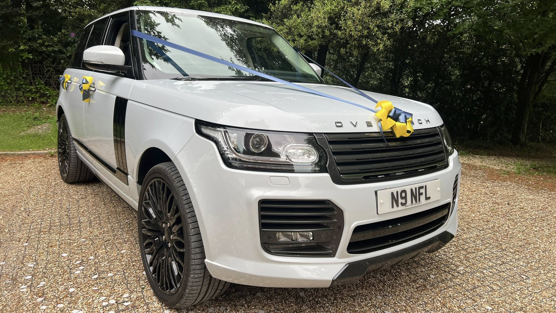 Modern WhiteRange Rover Voguw with yellow ribbons and bow