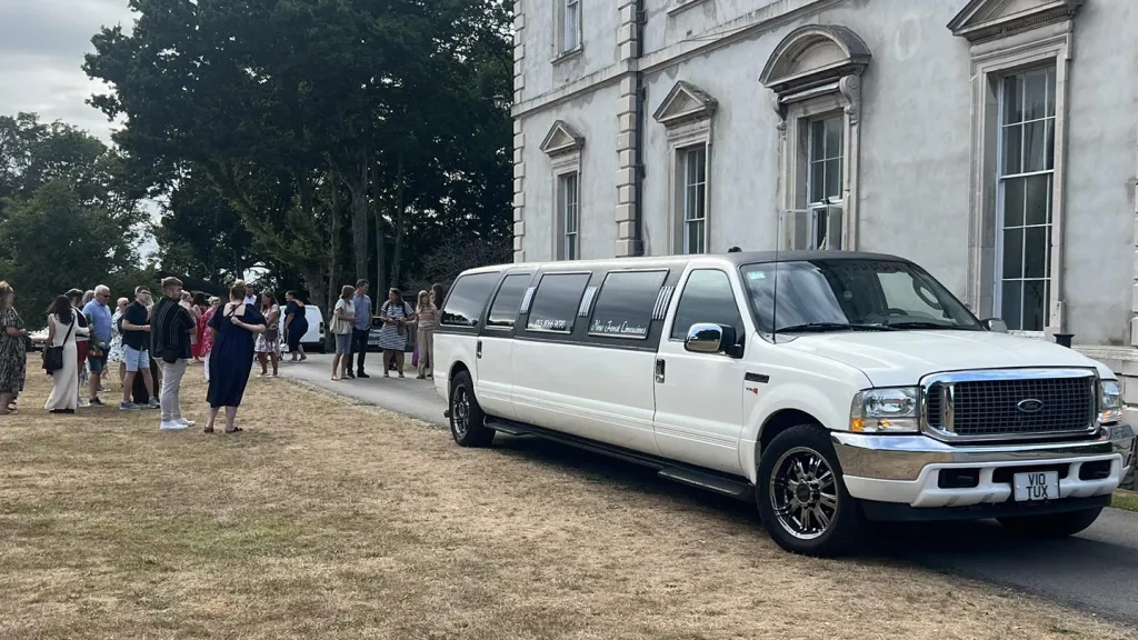 Ford Excursion Stretched Limousine with wedding guests in the background