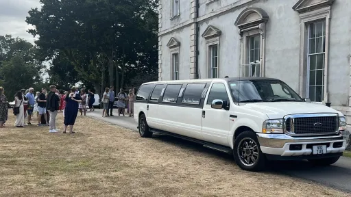 Ford Excursion Stretched Limousine with wedding guests in the background