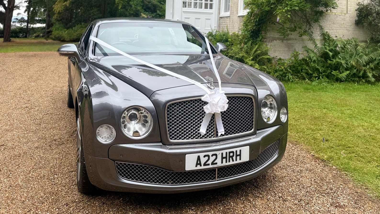 Bentley Mulsanne in front of a wedding venue in London dressed with white ribbons and bows