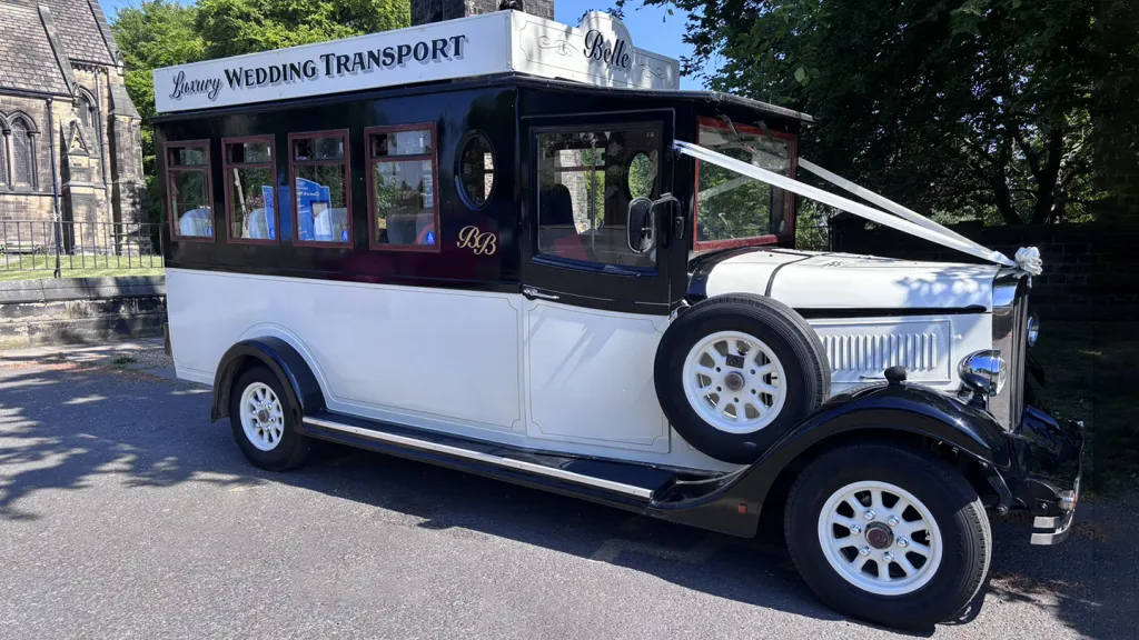 Right side view of Black and Ivory vintage Asquith bus waiting in front of a church in Leeds