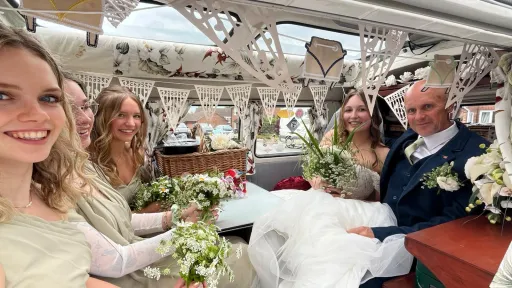 Bride, Groom and Bridesmaids seating inside a VW retro campervan